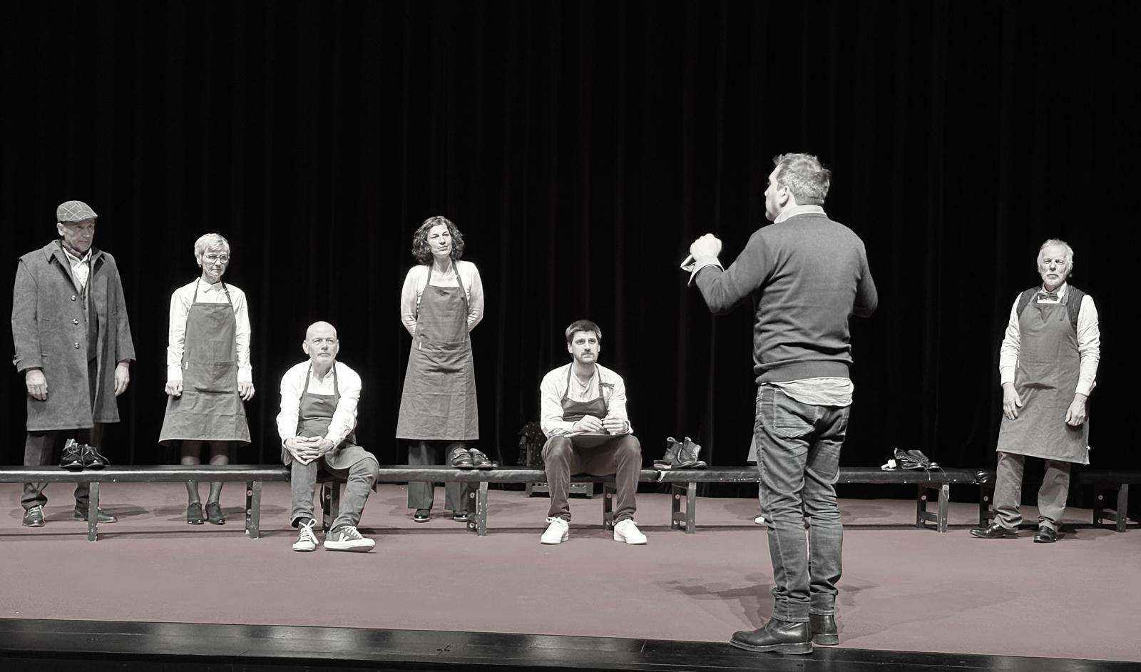 Fabrice Schillaci dirigeant un atelier th&eacute;&acirc;tre avec des participants sur sc&egrave;ne